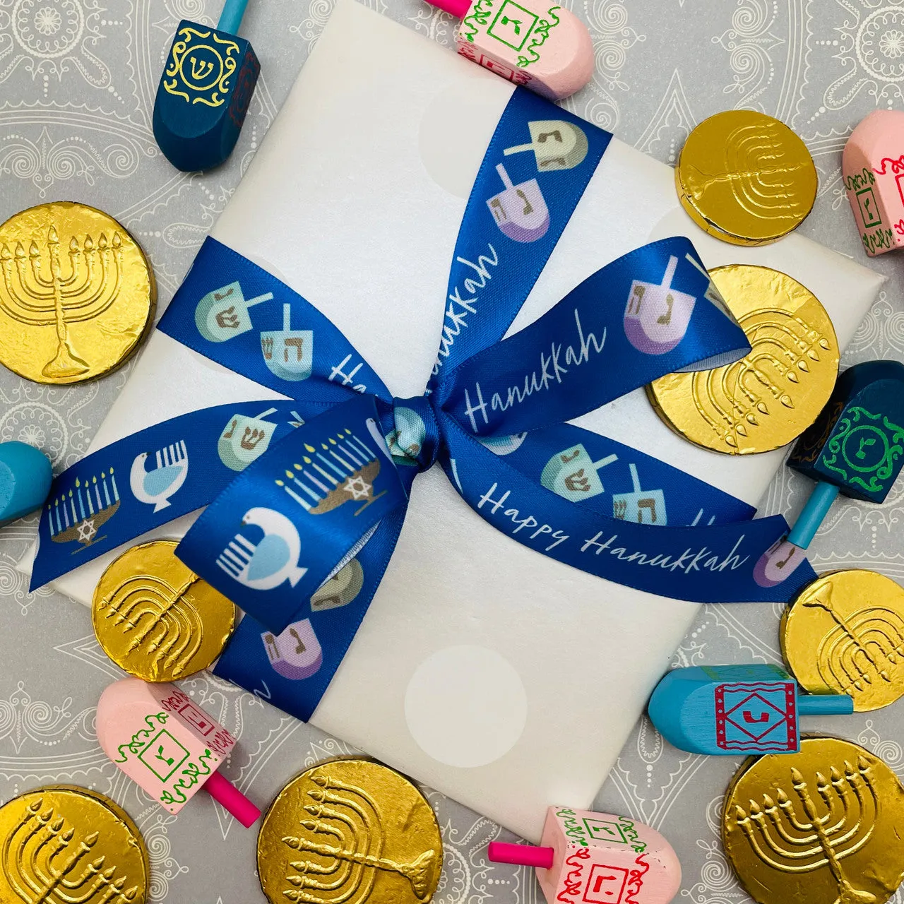 Hanukkah ribbon Happy Hanukkah with dreidels and menorahs on a blue background printed on 7/8" white single face satin
